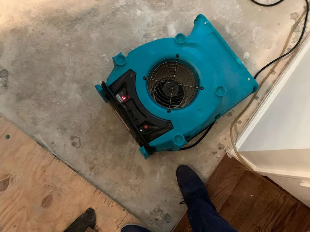 Air mover drying subfloor during Commercial Water Damage Restoration in De Pere